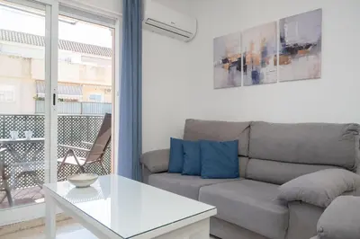 a living room with a couch and a table at SIBS Sanlúcar Océano-Ideal Familias-Parking y Wifi Gratis in Sanlúcar de Barrameda
