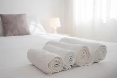 a pile of rolled towels on a bed at SIBS Sanlúcar Océano-Ideal Familias-Parking y Wifi Gratis in Sanlúcar de Barrameda