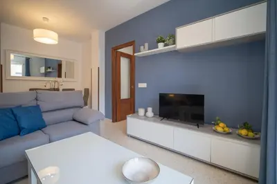 a living room with a couch and a television at SIBS Sanlúcar Océano-Ideal Familias-Parking y Wifi Gratis in Sanlúcar de Barrameda