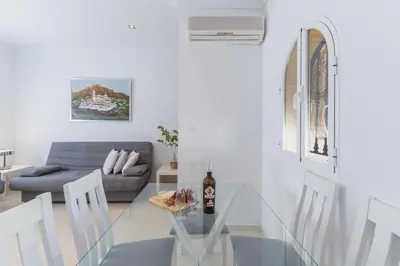 a white dining room with a table and chairs at Plaza del Cabildo Sanlucar Center by Valcambre in Sanlúcar de Barrameda