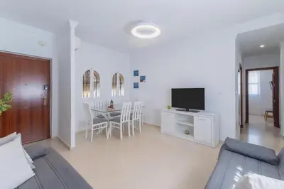 a bedroom with a bed and a wooden cabinet at Plaza del Cabildo Sanlucar Center by Valcambre in Sanlúcar de Barrameda