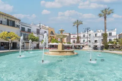 an outdoor patio with tables and chairs and umbrellas at Plaza del Cabildo Sanlucar Center by Valcambre in Sanlúcar de Barrameda