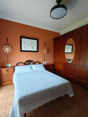 a bedroom with a bed with orange walls at El balconcito in Arcos de la Frontera
