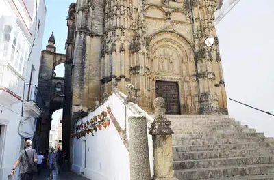 a man standing in front of a building with a statue at El balconcito in Arcos de la Frontera