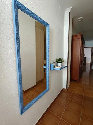 a mirror with a blue frame on a wall at El balconcito in Arcos de la Frontera