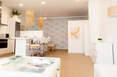 a kitchen with white cabinets and a dining room at Gallery Vistahermosa in El Puerto de Santa María