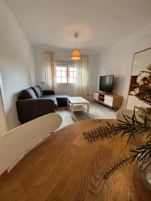 a living room with a table and a couch at La Joya de Apartamento in Jerez de la Frontera