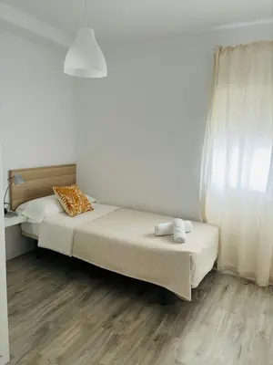 a bedroom with two beds and a window at La Joya de Apartamento in Jerez de la Frontera