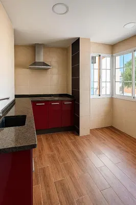 a kitchen with red cabinets and wooden floors and windows at La Joya de Apartamento in Jerez de la Frontera