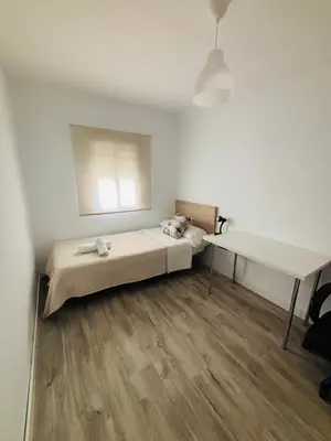 a white room with a bed and a desk at La Joya de Apartamento in Jerez de la Frontera