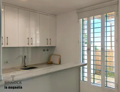 a white kitchen with a sink and a window at Spinola Beachfront Bungalows - Apartamentos bungalow en primera linea de playa en Sanlúcar de Barrameda in Sanlúcar de Barrameda