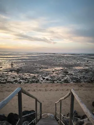 a view of the beach with a person walking on the beach at Spinola Beachfront Bungalows - Apartamentos bungalow en primera linea de playa en Sanlúcar de Barrameda in Sanlúcar de Barrameda
