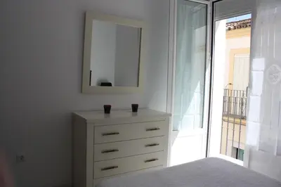 a bedroom with a dresser with two cups on it at Apartamento Centro Plaza del Cabildo in Sanlúcar de Barrameda