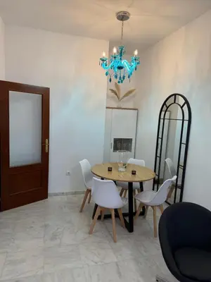 a dining room with a table and chairs and a chandelier at Apartamento Centro Plaza del Cabildo in Sanlúcar de Barrameda
