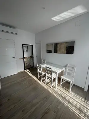 a white dining room with a white table and chairs at Alojamiento rural colarte in Conil de la Frontera