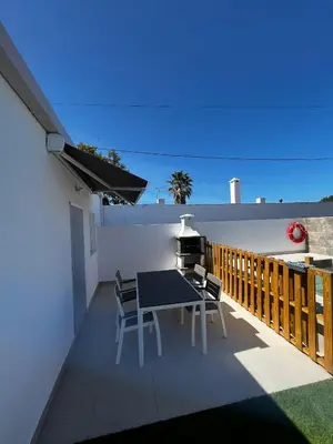a patio with a table and chairs on a balcony at Alojamiento rural colarte in Conil de la Frontera