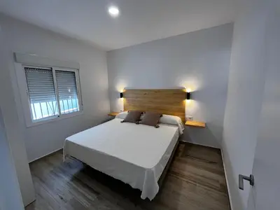 a bedroom with a large bed with a wooden headboard at Alojamiento rural colarte in Conil de la Frontera