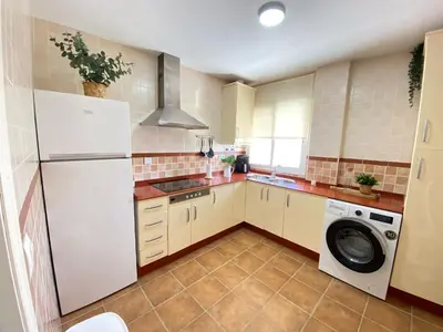 a kitchen with a white refrigerator and a washing machine at Apartamento Baluarte in Sanlúcar de Barrameda