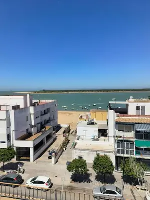 a view of a city with a beach and buildings at Apartamento Baluarte in Sanlúcar de Barrameda