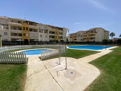 a swimming pool in front of some apartment buildings at Apartamento La Laguna in Chipiona