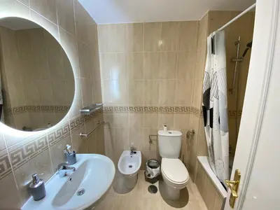 a bathroom with a sink and a toilet and a mirror at Apartamento La Laguna in Chipiona