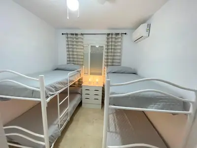 a bedroom with two bunk beds and a mirror at Apartamento La Laguna in Chipiona