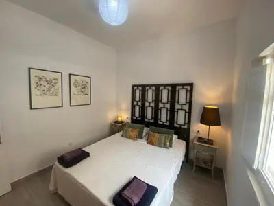 a bedroom with a white bed with two pillows at Casa Santo Domingo, Centro-Playa in Chipiona