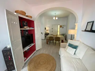 a living room with a white couch and a tv at Casa Santo Domingo, Centro-Playa in Chipiona