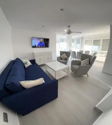 a living room with a blue couch and a tv at Apartamento Arena y sal in El Puerto de Santa María