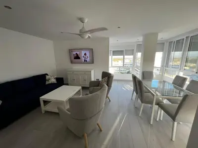 a living room with a couch and a table and chairs at Apartamento Arena y sal in El Puerto de Santa María