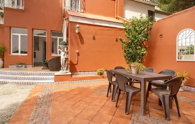 a patio with a table and chairs in front of a building at Stunning Home In Chiclana De La Fronter in Novo Sancti Petri