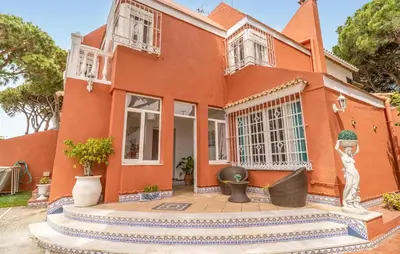 an orange house with a statue in front of it at Stunning Home In Chiclana De La Fronter in Novo Sancti Petri