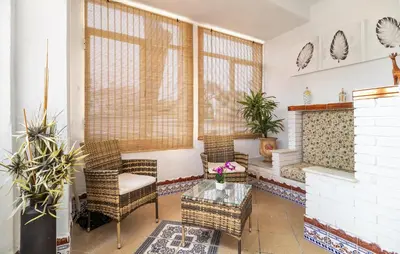 a living room with chairs and a fireplace at Stunning Home In Chiclana De La Fronter in Novo Sancti Petri