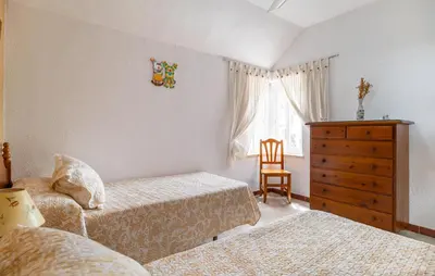 a bedroom with two beds and a dresser and a window at Stunning Home In Chiclana De La Fronter in Novo Sancti Petri