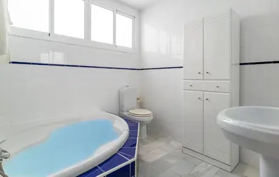 a bathroom with a tub and a toilet and a sink at Stunning Home In Chiclana De La Fronter in Novo Sancti Petri