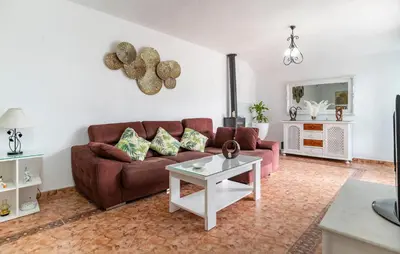 a living room with a brown couch and a table at Stunning Home In Chiclana De La Fronter in Novo Sancti Petri