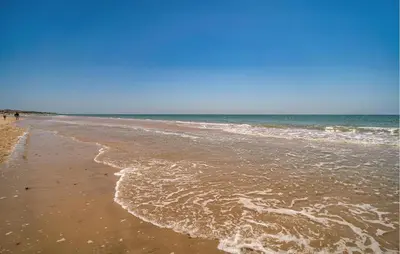 a sandy beach with waves coming in from the ocean at Stunning Home In Chiclana De La Fronter in Novo Sancti Petri