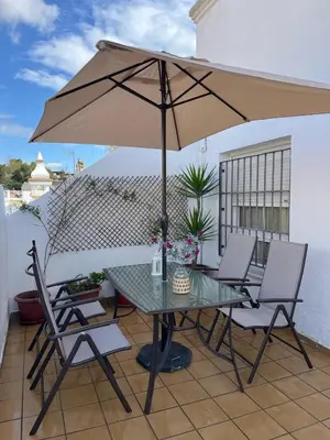a table and chairs with an umbrella on a patio at Ático de Marta, Pleno Centro-Terraza 34m2 in Sanlúcar de Barrameda