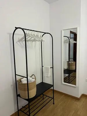 a black shelf with a basket and a mirror at Ático de Marta, Pleno Centro-Terraza 34m2 in Sanlúcar de Barrameda