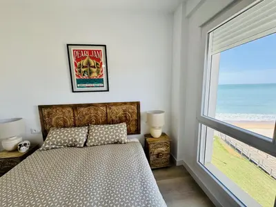 a bedroom with a bed and a window with the beach at El Vigia Grupo AC Gestion in Vista Hermosa