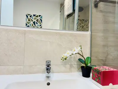 a bathroom sink with a pink box and a vase with flowers at El Vigia Grupo AC Gestion in Vista Hermosa