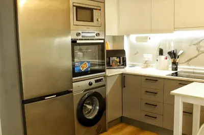 a kitchen with a washing machine and a microwave at Apartamento Castillo Deluxe in Sanlúcar de Barrameda