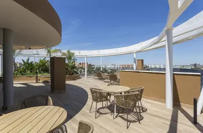 a patio with tables and chairs on a roof at Sunset Vibes at Sky Garden Jerez in Jerez de la Frontera