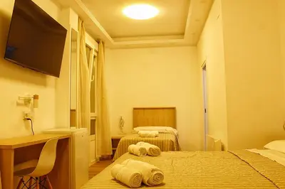 a room with two beds and a desk and a television at Habitaciones Castillo Deluxe in Sanlúcar de Barrameda