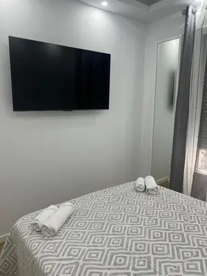 a bedroom with a bed with a flat screen tv on the wall at Habitaciones Castillo Deluxe in Sanlúcar de Barrameda