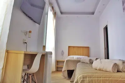 a bedroom with two beds and a desk and a table at Habitaciones Castillo Deluxe in Sanlúcar de Barrameda