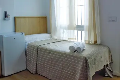 a bedroom with a bed with two towels on it at Habitaciones Castillo Deluxe in Sanlúcar de Barrameda