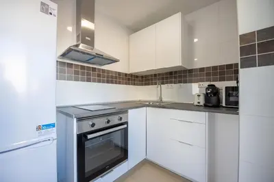 a kitchen with white cabinets and a stove top oven at Luminoso Apartamento con Balcón in El Puerto de Santa María