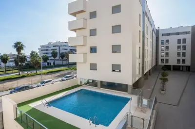 a building with a swimming pool next to a building at Luminoso Apartamento con Balcón in El Puerto de Santa María