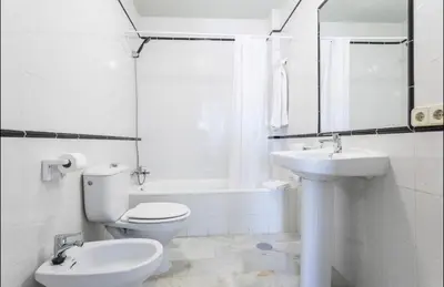 a white bathroom with a toilet and a sink at Luminoso y acogedor apartamento en el centro in El Puerto de Santa María